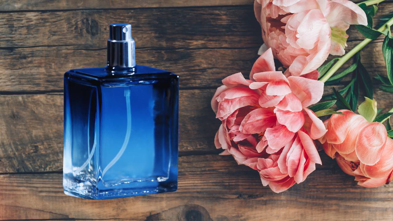 Um frasco de perfume masculino ao lado de rosas
