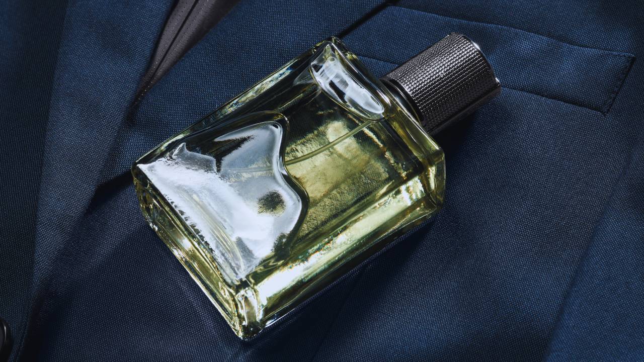 Um frasco de perfume sobre um blazer masculino